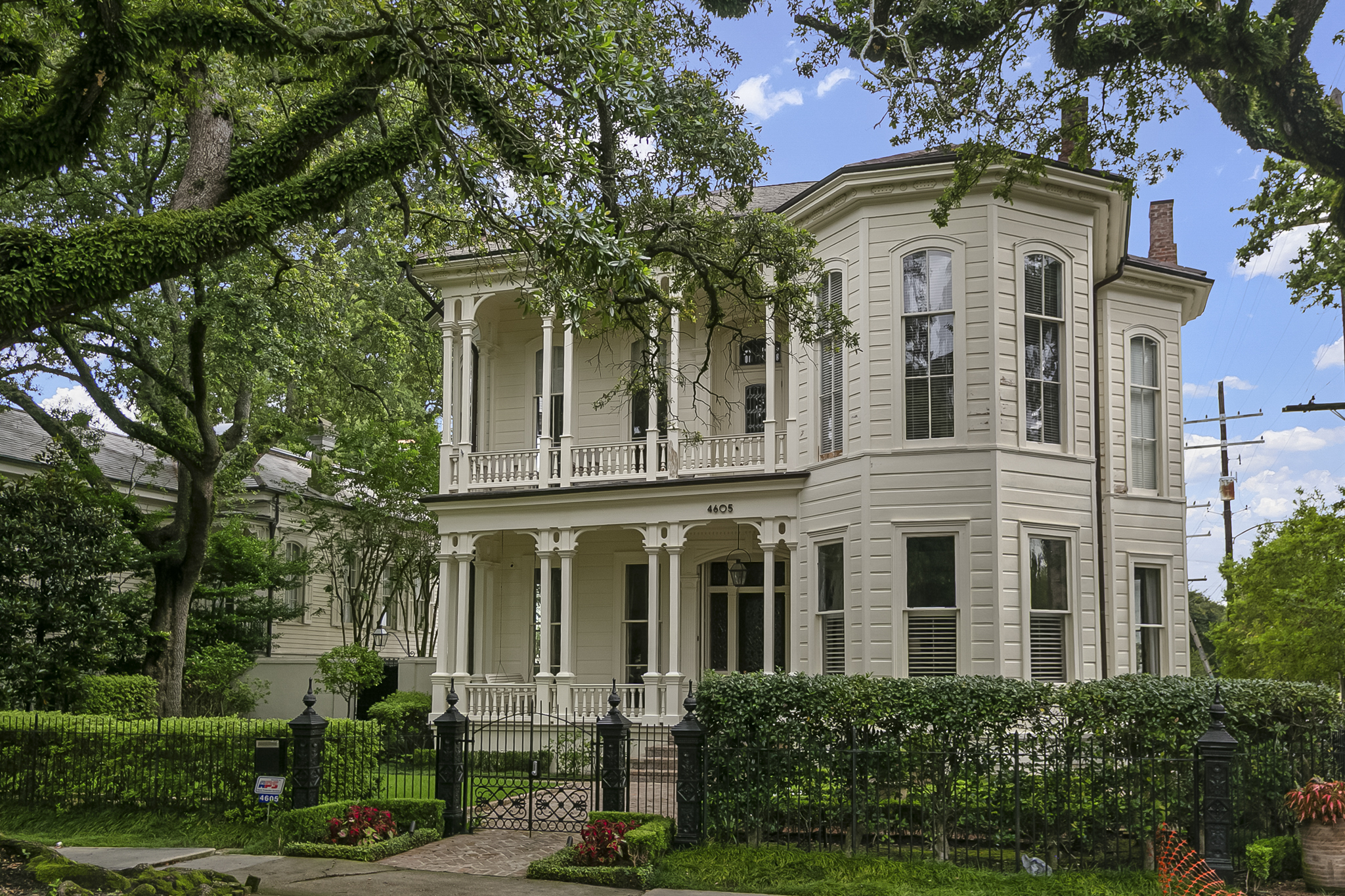 Restored historic Victorian home with double galleries on a tree-lined Uptown New Orleans street